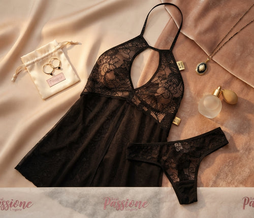 Flat lay of Passione code black lace-trim slip nightwear set with Soft Secrets branding, gold mirror, and rose petals.
