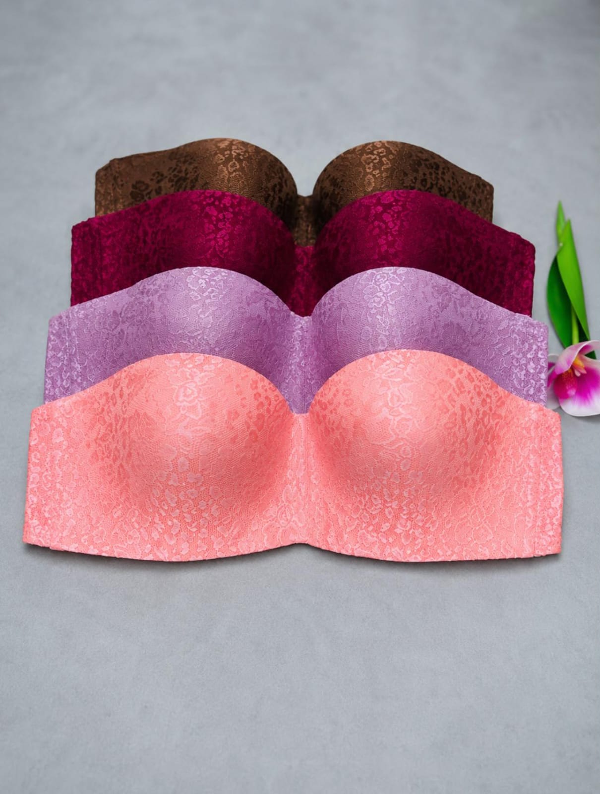 Multicolor lace strapless padded bandeau bra with seamless design in pink, lavender, burgundy, and brown, ideal for everyday comfort and invisible support under off-shoulder outfits.