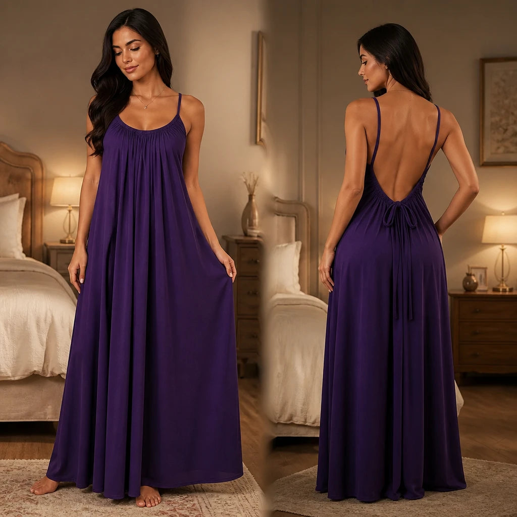 Model wearing a purple backless maxi dress and silky lounge gown by Soft Secrets in a luxury bedroom setting.